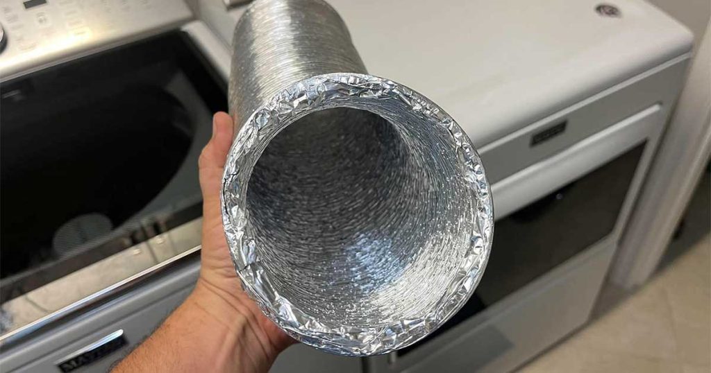 Jonathan showing a dryer vent hose above a dryer in The Villages